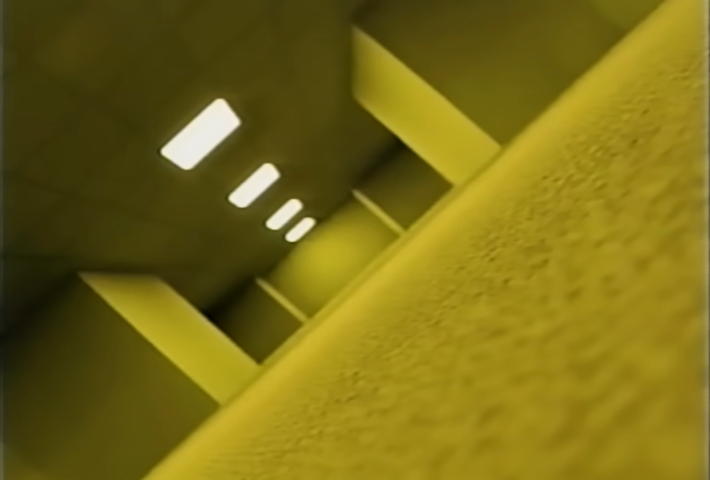 Pasillo infinito iluminado por luz amarilla y tenue, con paredes monótonas y moqueta, al estilo de los espacios laberínticos de los Backrooms